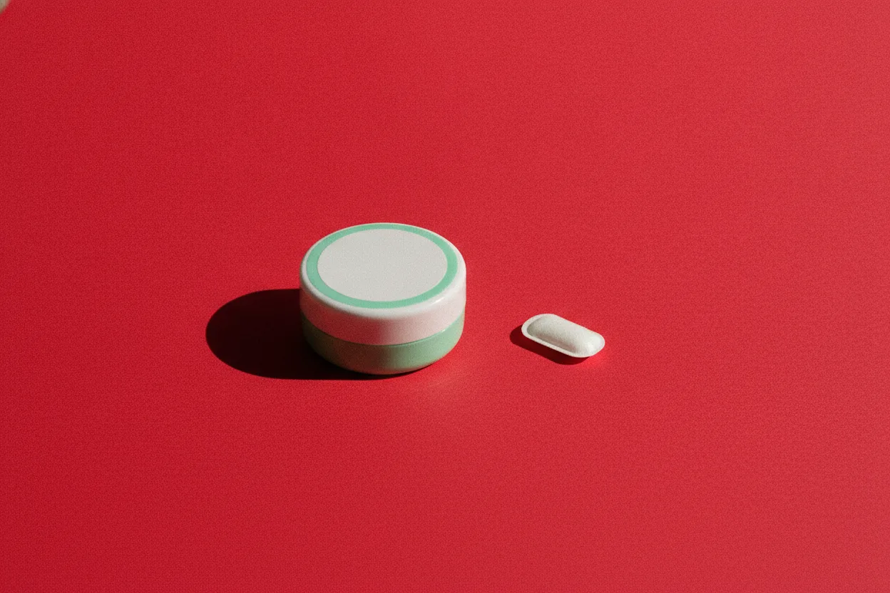 A small round mint-and-white tin with a closed lid beside a single white oval pouch on bright red paper